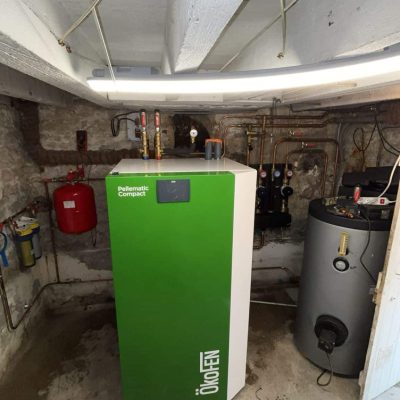 Chaudière ÖkoFEN Pellomatic Compact verte avec ballon d'eau chaude dans une cave